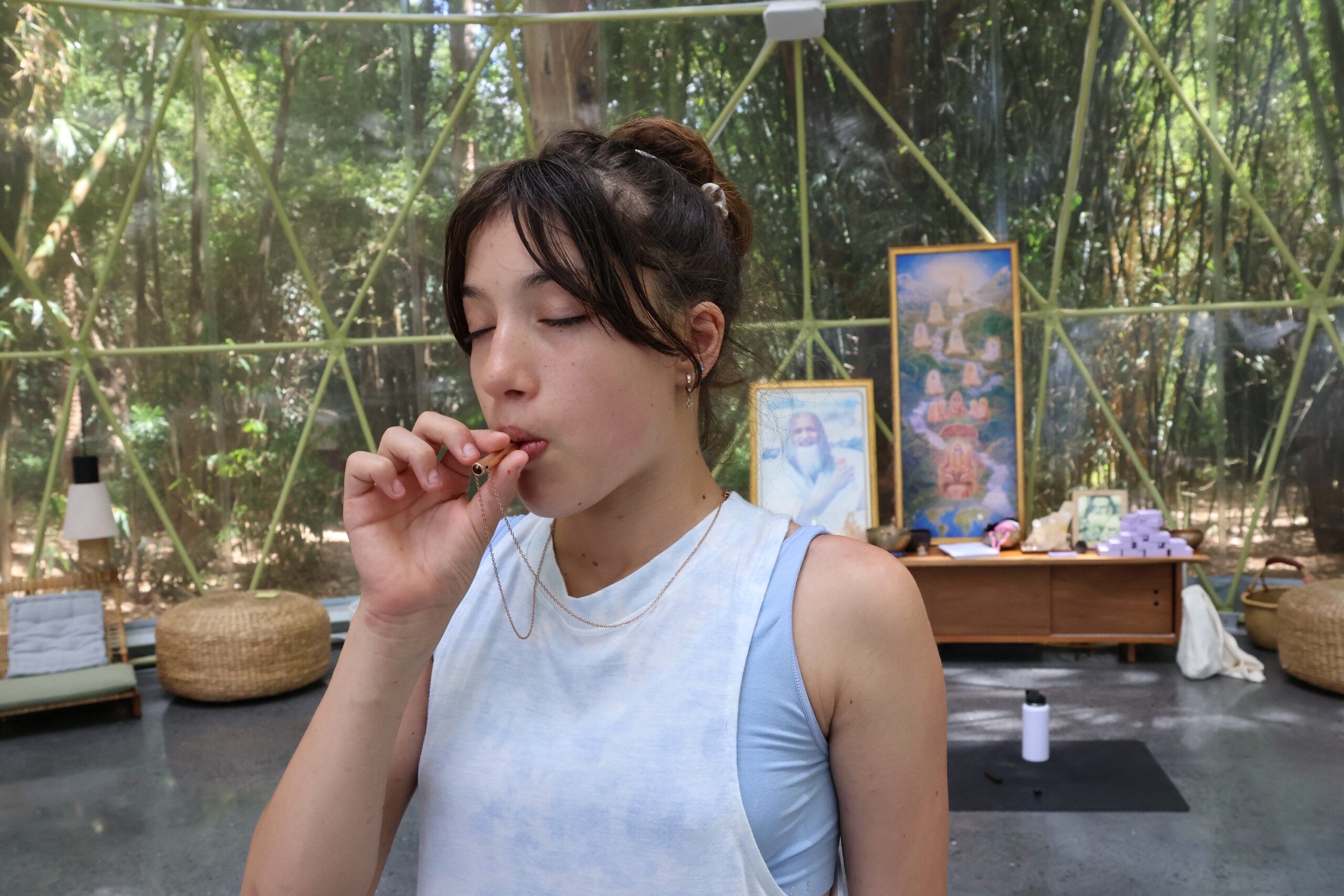 A young person using the Yasu™ breathing necklace in a calm outdoor setting